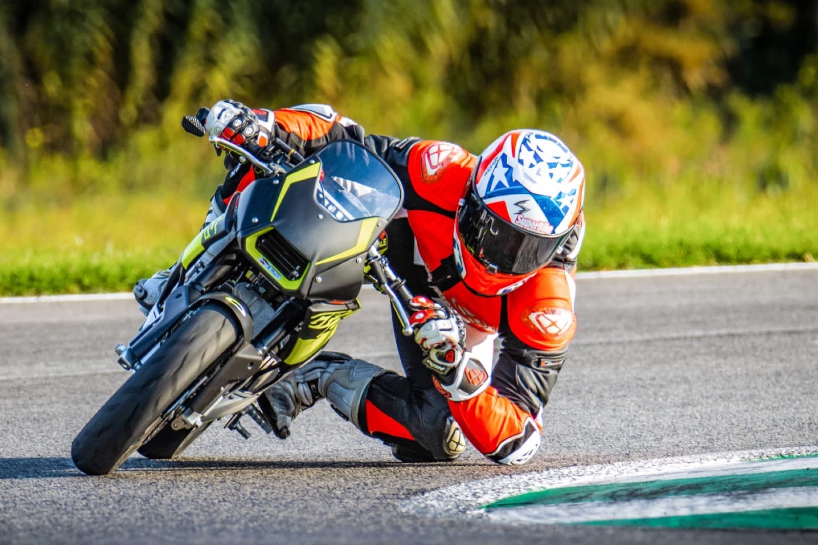 Pilota in piega con il gomito a terra durante una prova su Ohvale GP-2